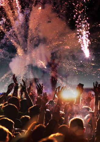 crowd with raised hands at concert festival banner